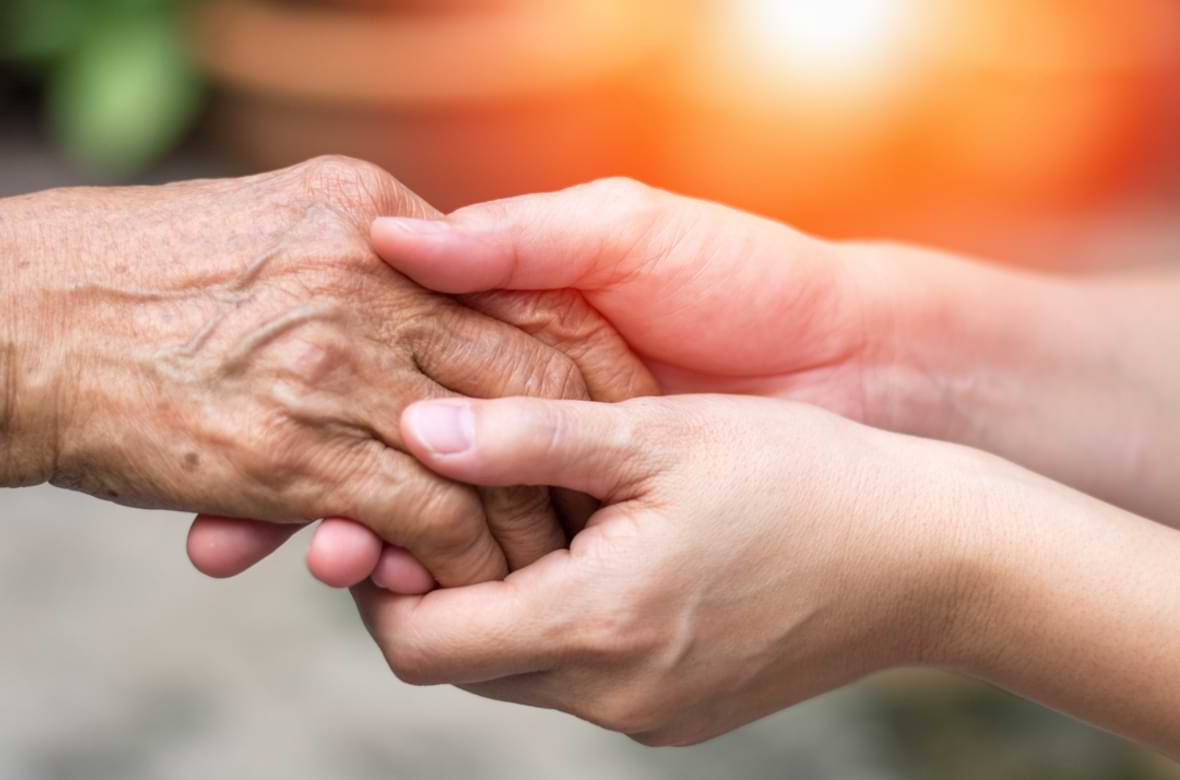 Younger person holding the hand of an elder